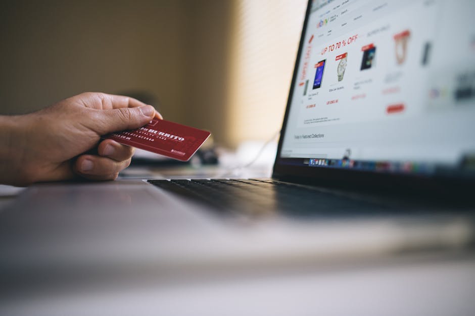 illustration: laptop with e-shop and bank card in hand